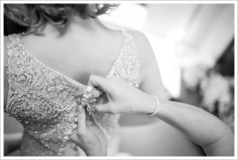 Buttoning the dress | Joseph and Breanne's Village by the Sea Wedding