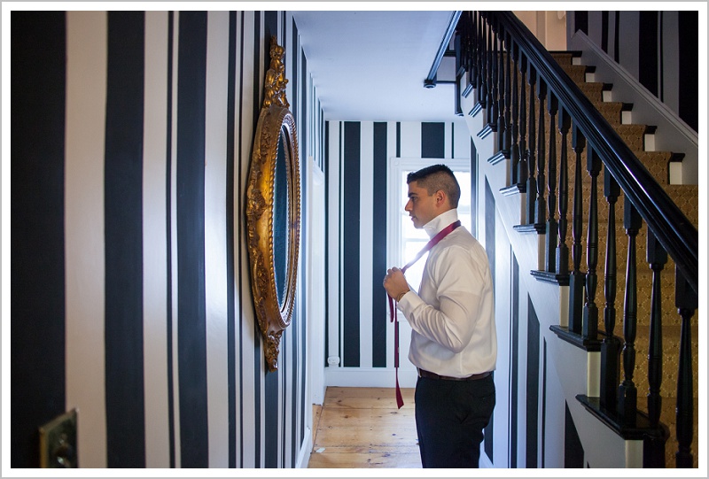 Groom tying tie by stairs - Adam & Ali's Wedding at The Barn at Walnut Hill | LAD Photography