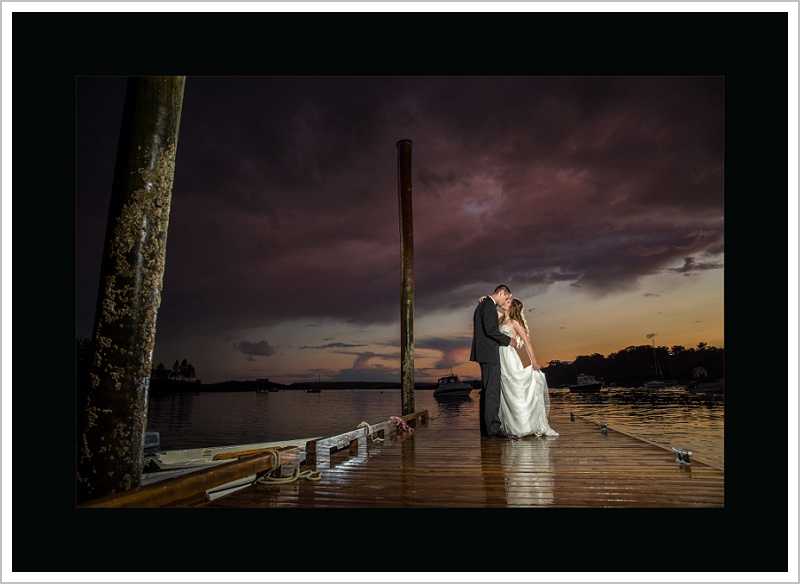 Bride and Groom on dock with stormy sky - Maine's Top Wedding Photographer