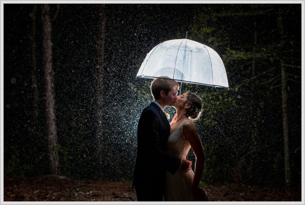 Katie and James' Hidden Pond Wedding | under an umbrella in the rain