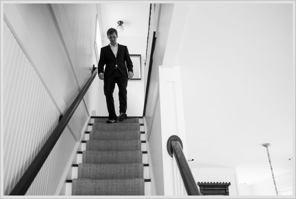 Katie and James' Hidden Pond Wedding | Groom coming down the stairs