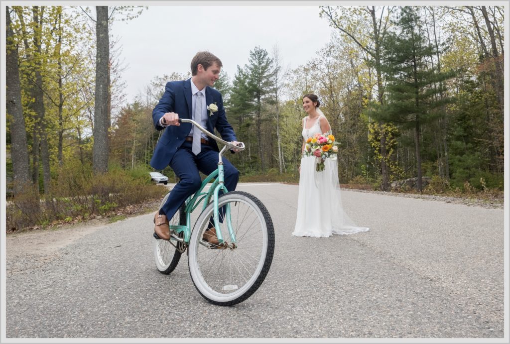 Katie and James' Hidden Pond Wedding | Groom on vintage Bicycle while Bride looks on