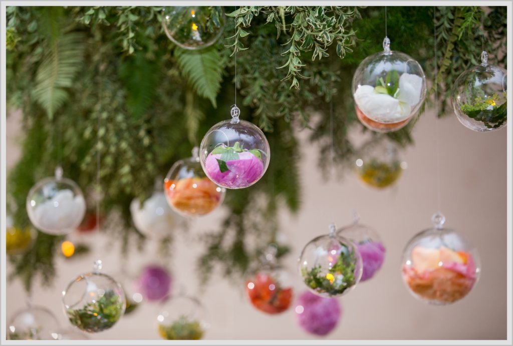 Katie and James' Hidden Pond Wedding | venue details flowers in glass orbs hanging from greenery