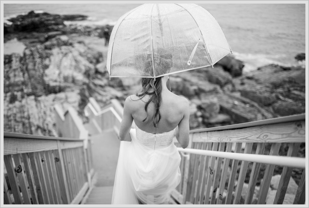 Brian + Tracy's Cliff House Wedding | Bride going down stairs with umbrella